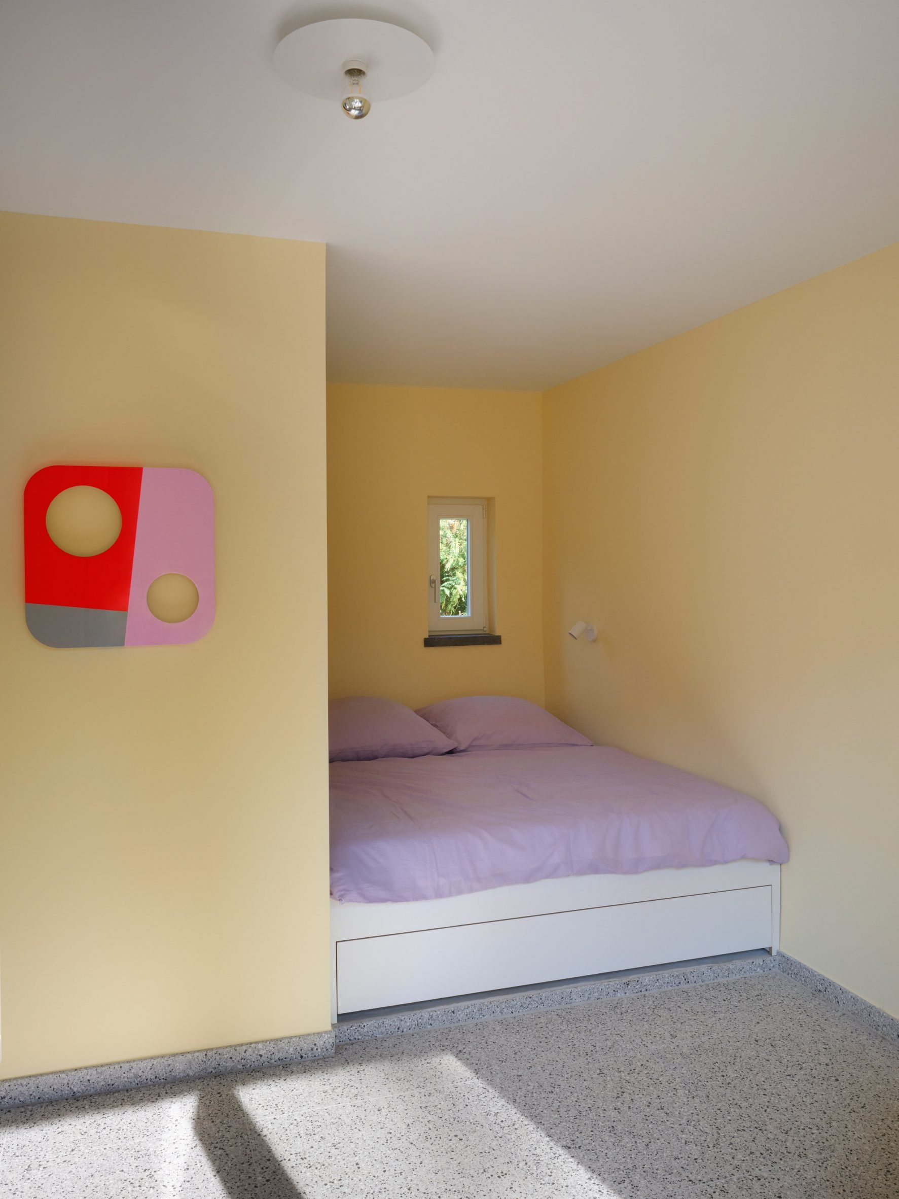Butter yellow walls wrap around the lilac bed 