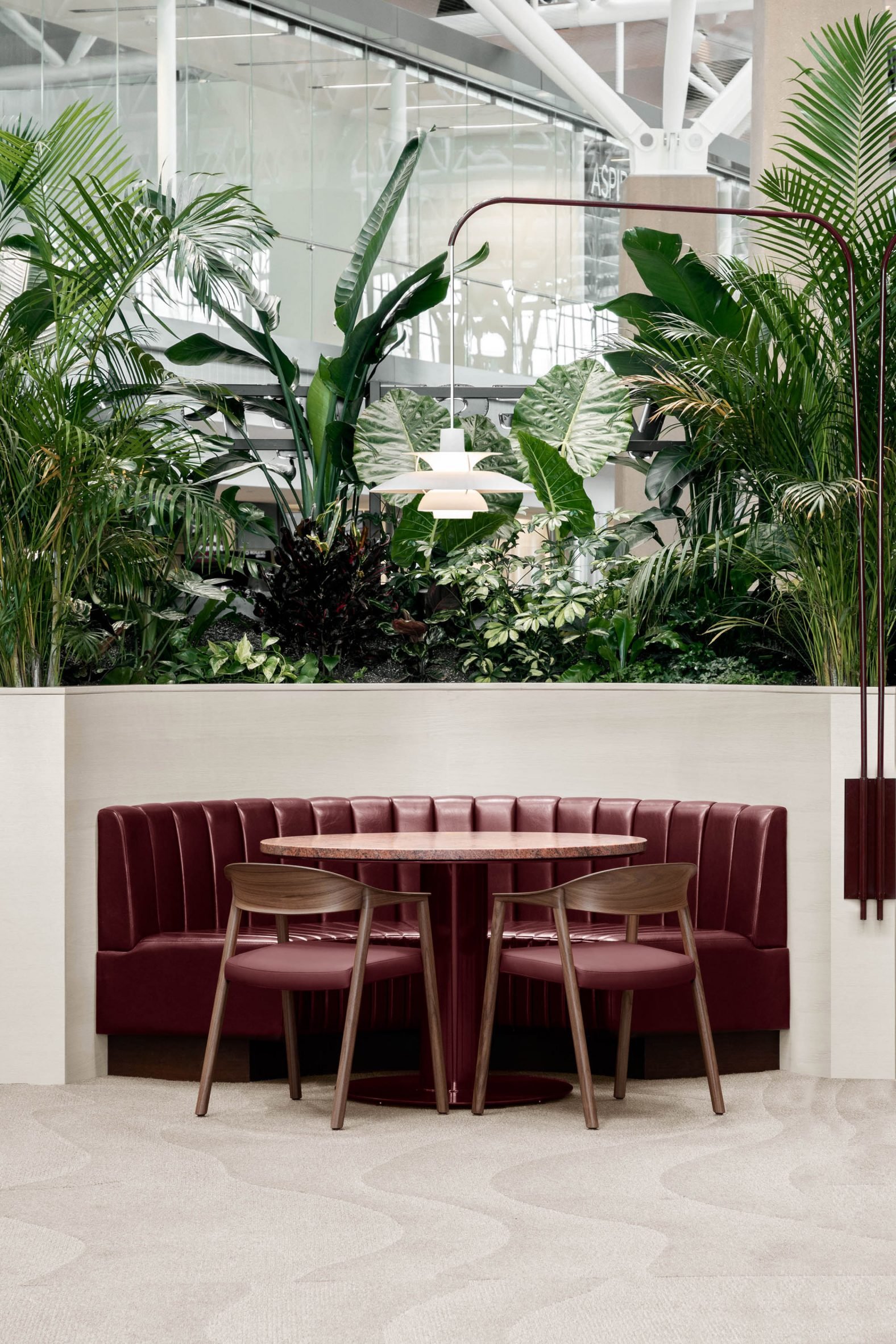 Booth featuring oxblood-coloured leather seats, tables and dining chairs