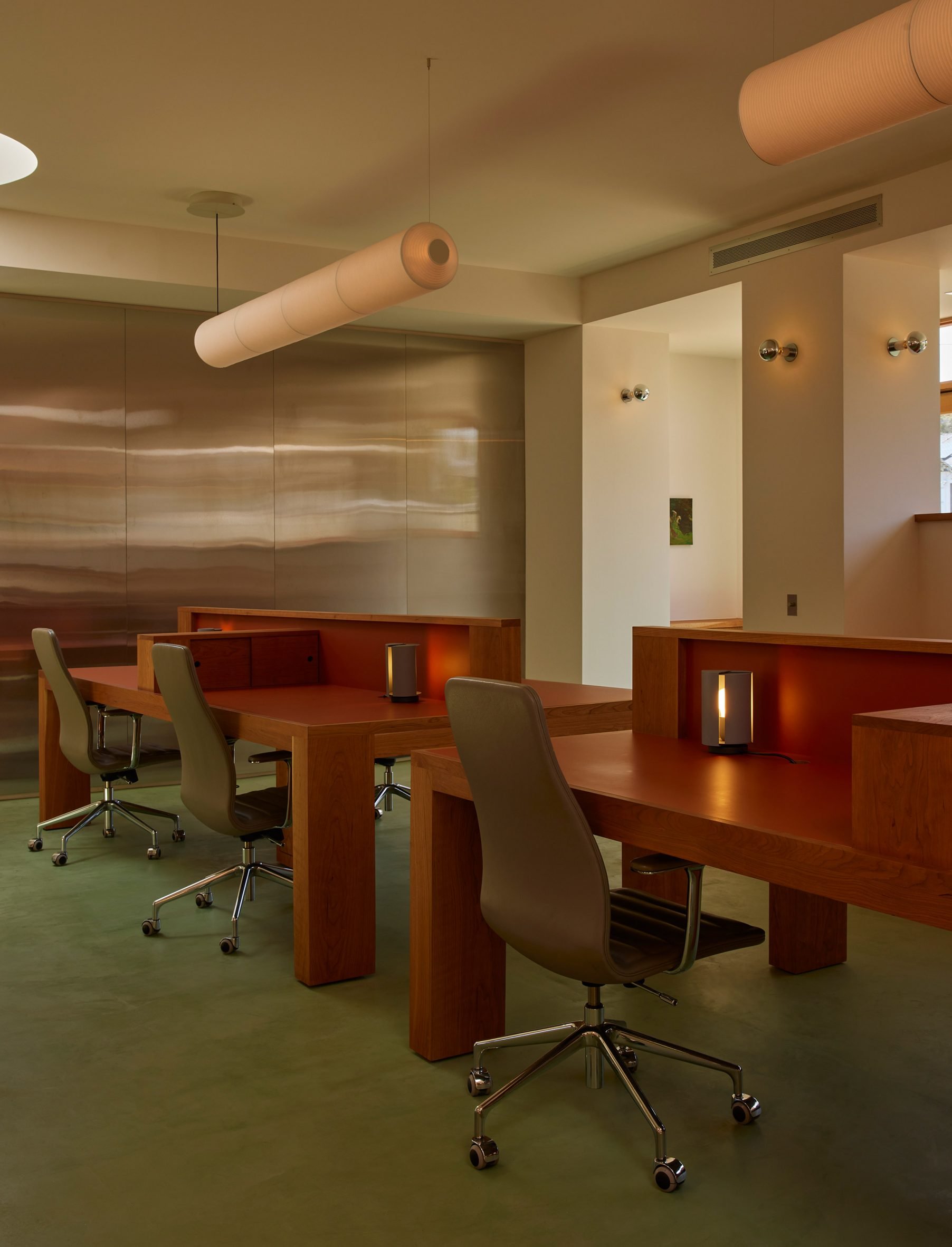 Central workstations sat on green carpet and against stainless steel panels 