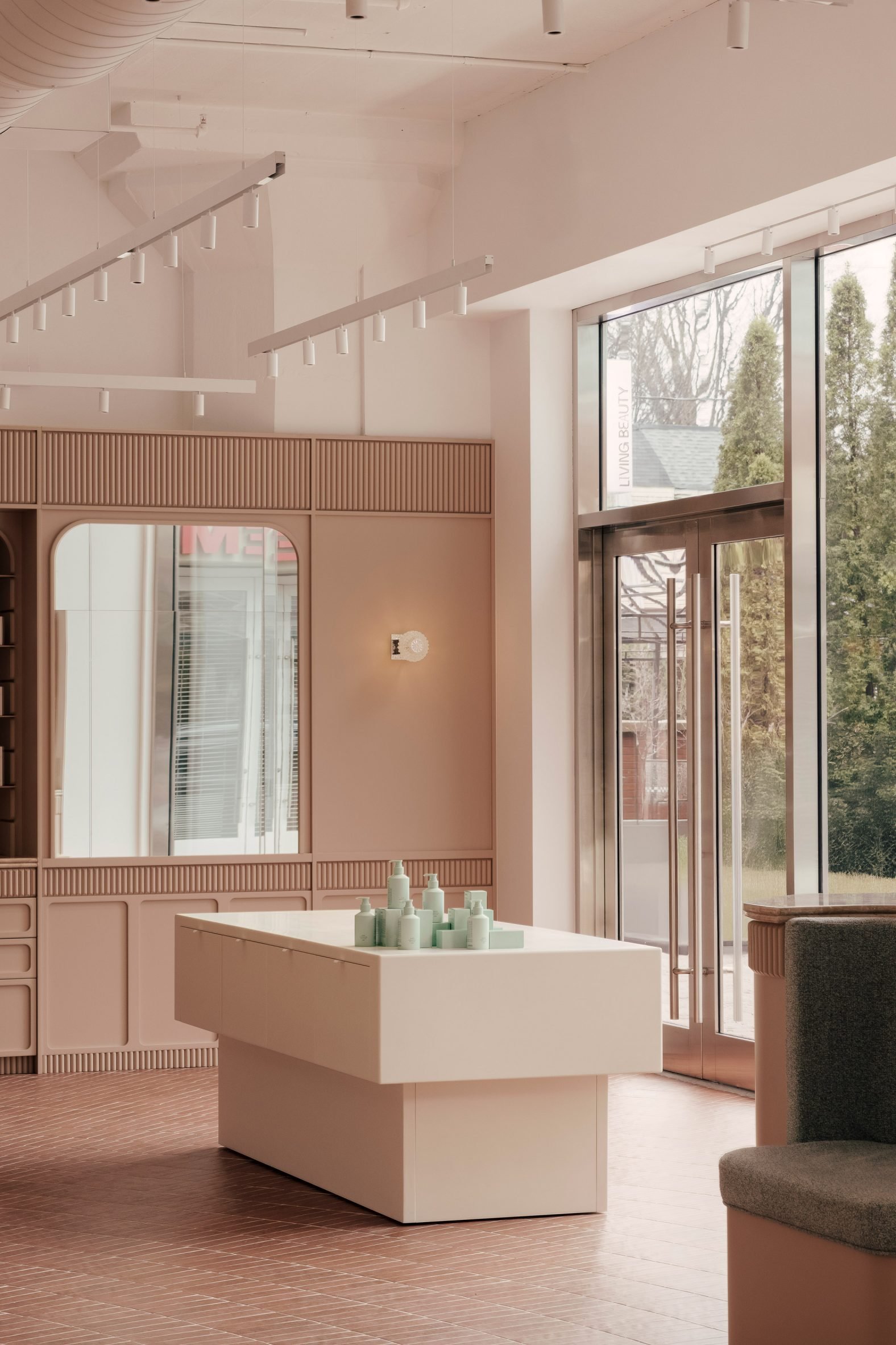 White Corian display plinths against clay-toned millwork