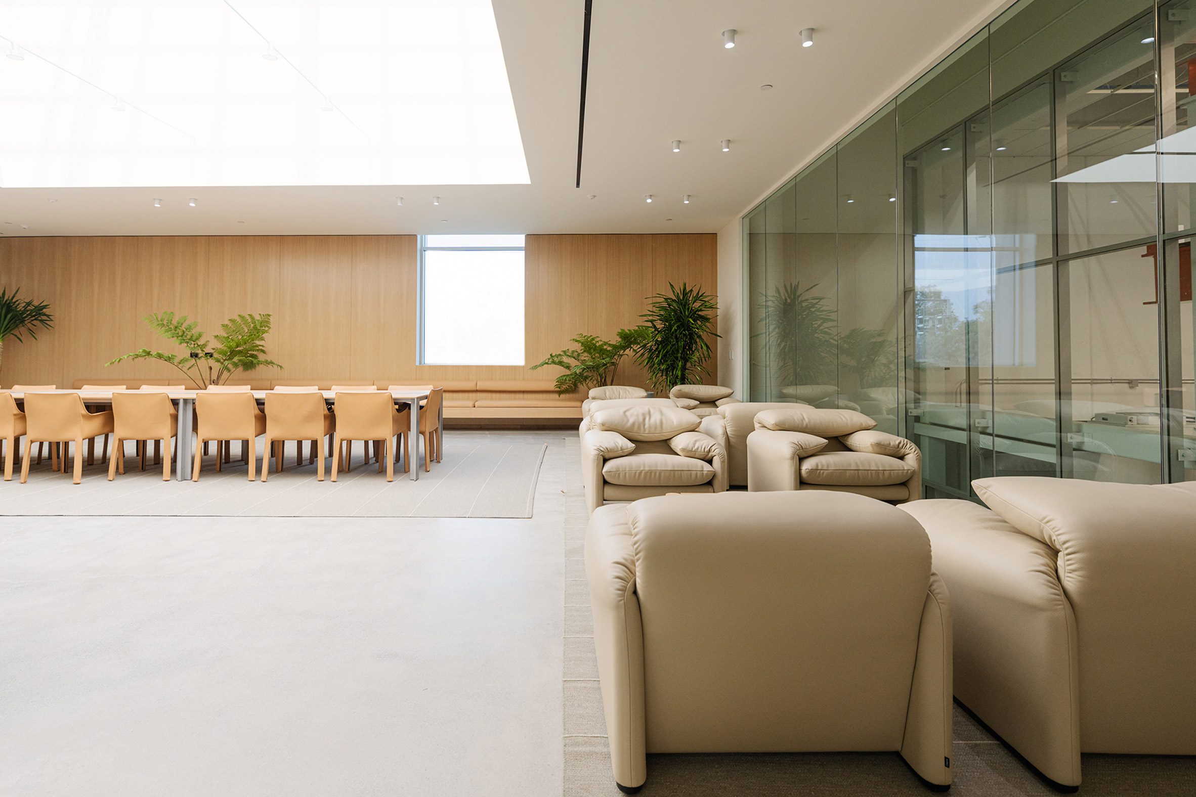 Photo of the SkyLab lounge at Vast's headquarters showing plush leather armchairs, a wood-panelled back wall, and a glass internal wall allowing views into the workplace